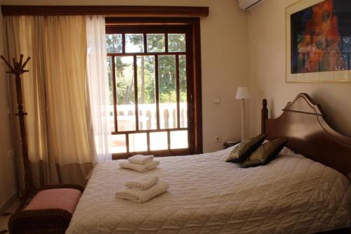 a bedroom with a large bed with towels on it at Candia House in Kandia