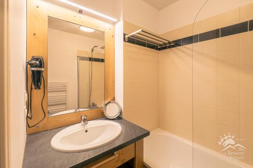 une salle de bain avec un lavabo, un miroir et une baignoire dans l'établissement Résidence les Terrasses De La Bergerie (by Sabine et JeanKry), à Orcières