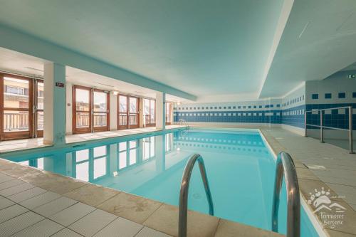 - une grande piscine d'eau bleue dans un bâtiment dans l'établissement Résidence les Terrasses De La Bergerie (by Sabine et JeanKry), à Orcières