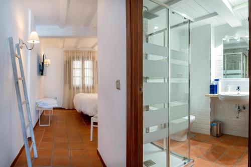 Habitación con una puerta de cristal que conduce a un dormitorio. en Natural&Mente Valle del Jerte, en El Torno