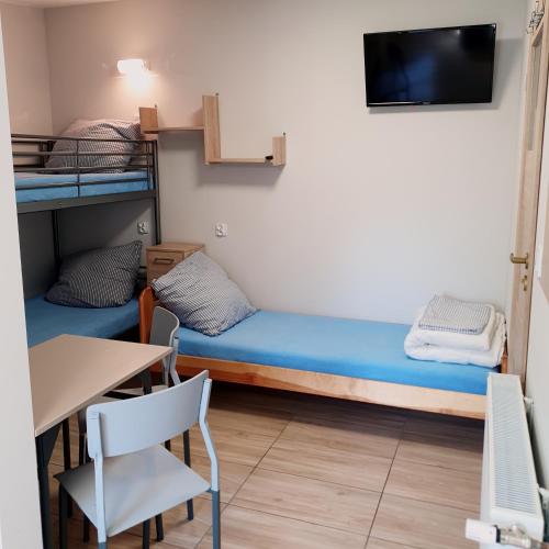 a room with two bunk beds and a table at Noclegi Silesia ASTER in Tychy