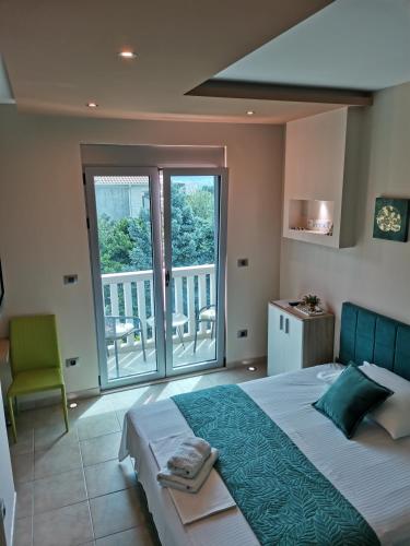 a bedroom with a large bed and a balcony at Vila Jadranka Apartments in Herceg-Novi