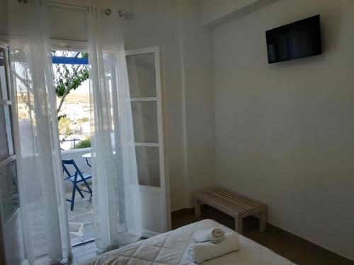 a bedroom with a bed and a tv and a window at Serene Hill in Naousa