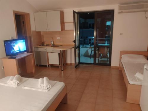a large living room with a television and a kitchen at Apartments Mare Budva in Budva