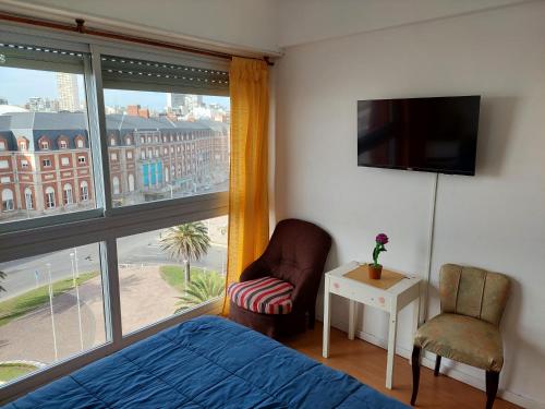 1 dormitorio con 1 cama, 1 silla y 1 ventana en Hermoso depto con vista al mar en Mar del Plata