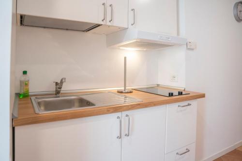 a kitchen with white cabinets and a sink at MIMOSA - Villa Luisa: Pace, Relax a 2 passi dal mare in Casarza Ligure