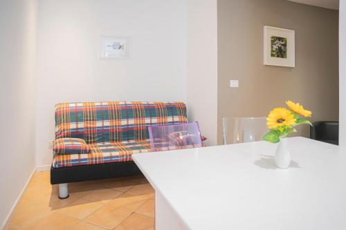 a living room with a chair and a vase with a flower at MIMOSA - Villa Luisa: Pace, Relax a 2 passi dal mare in Casarza Ligure