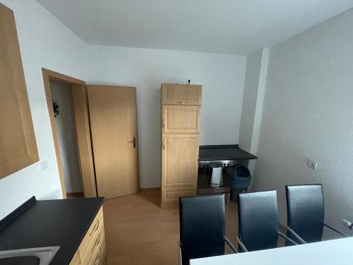 a room with chairs and a table and a cabinet at Monteurwohnungen-Dinslaken in Dinslaken