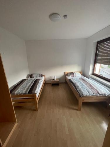 a room with two beds and a window at Monteurwohnungen-Dinslaken in Dinslaken