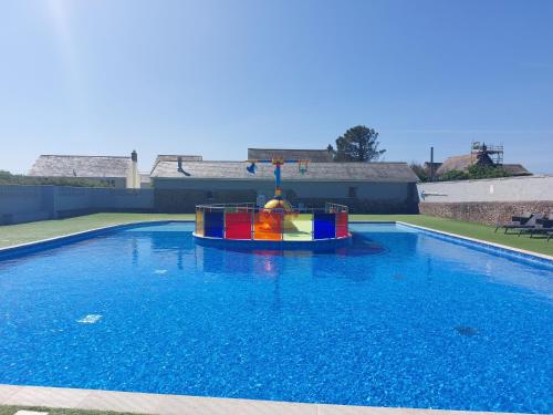 a large swimming pool with a toy in the water at Bude Coastal Lodge in Bude