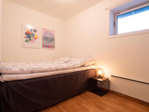 a bed in a room with a window at Cozy apartment by the sea in Tromsø