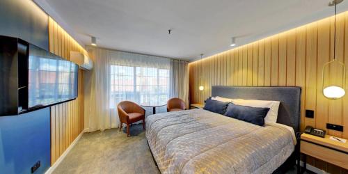 a bedroom with a bed and a flat screen tv at Distinction Whangarei Hotel & Conference Centre in Whangarei