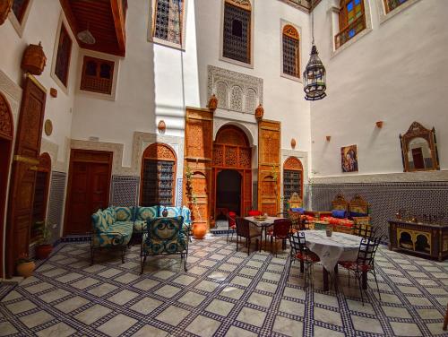 een kamer met stoelen en tafels in een gebouw bij Riad Fès Center in Fès