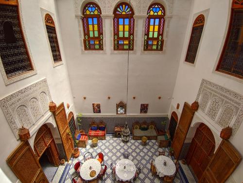 een kamer met tafels en stoelen aan het plafond bij Riad Fès Center in Fès