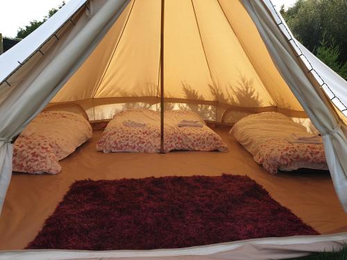 Kama o mga kama sa kuwarto sa Glamping in the Kent weald nr Tenterden Spacious quite site up to 6 equipped tents, each group has their own facilities Tranquil and beautiful rural location yet just an hour to London