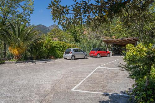 two cars parked in a parking lot with mountains in the background at MIMOSA - Villa Luisa: Pace, Relax a 2 passi dal mare in Casarza Ligure