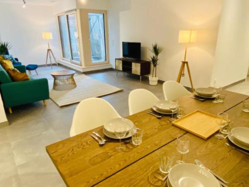 ein Wohnzimmer mit einem Holztisch und weißen Stühlen in der Unterkunft Brand New 2 bedrooms with Parking and Terrace - 142-96 in Luxemburg (Stadt)