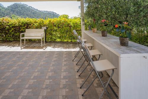 a row of chairs sitting at a bar with a bench at MIMOSA - Villa Luisa: Pace, Relax a 2 passi dal mare in Casarza Ligure