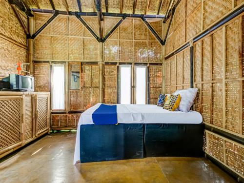 um quarto com uma cama num quarto com paredes de bambu em OYO Homes 91067 Desa Wisata Santanamekar em Rajapolah