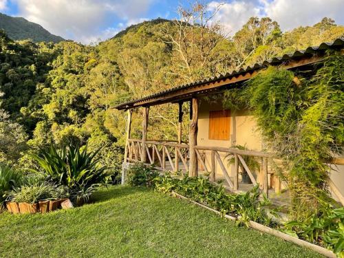 een huis in het midden van een bos met een brug bij Rancho Pedra do Picú in Itamonte