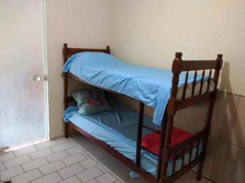 a bunk bed in a room with a blue bed at Casa de praia navegantes, próximo aeroporto in Navegantes