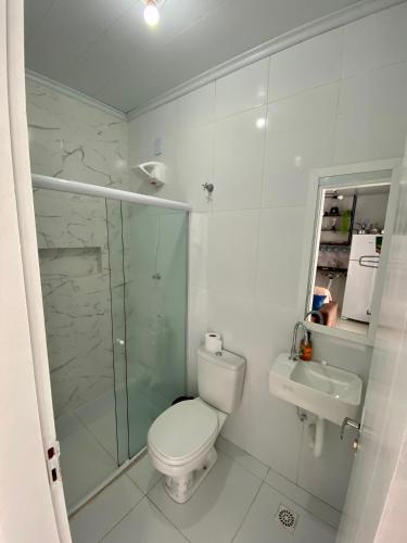 a bathroom with a toilet and a shower and a sink at Temporada 737 in Aracaju