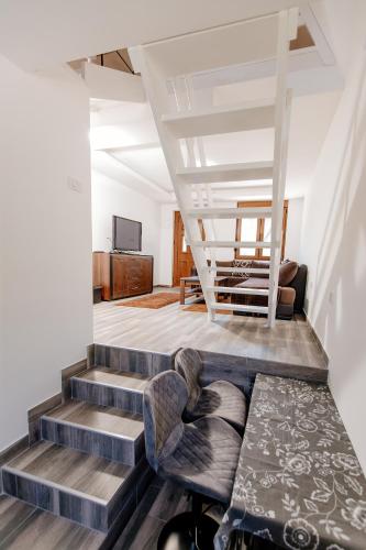 a living room with stairs and a chair and a table at Bungalow Holiday in Pluzine