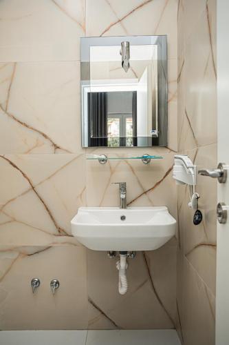 a bathroom with a sink and a mirror at Hotel SUNSET GL in Vlorë