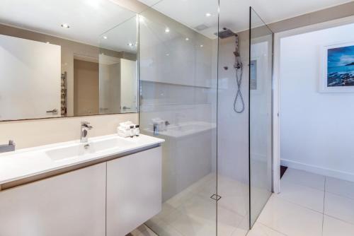 y baño blanco con lavabo y ducha. en Whitsunday Apartment 1306, en Hamilton Island