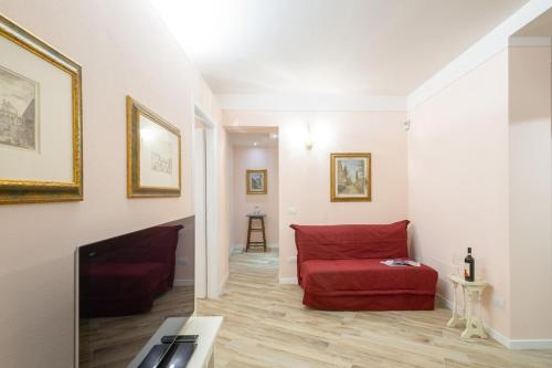 a living room with a red couch and a fireplace at Residenza dei Piaceri Perduti-Rosa in Lastra a Signa