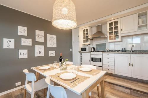 een keuken met een tafel en stoelen en een keuken met witte kasten bij Casa Huarpe in Mendoza