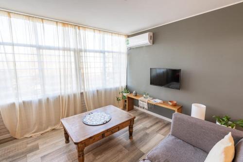 een woonkamer met een bank en een tafel bij Casa Huarpe in Mendoza