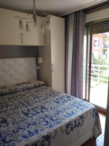 a bedroom with a bed with a blue and white comforter at Keymar in San Miguel de Meruelo
