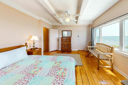 a bedroom with a bed and a view of the ocean at Retreat Cottage in Plymouth