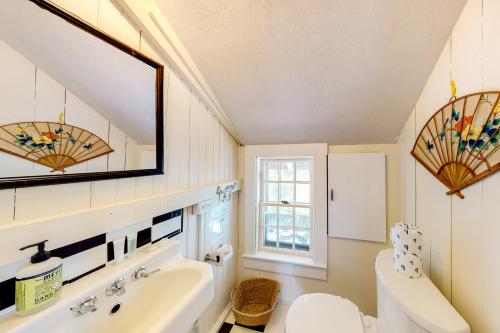 un bagno con lavandino, WC e specchio di Retreat Cottage a Plymouth