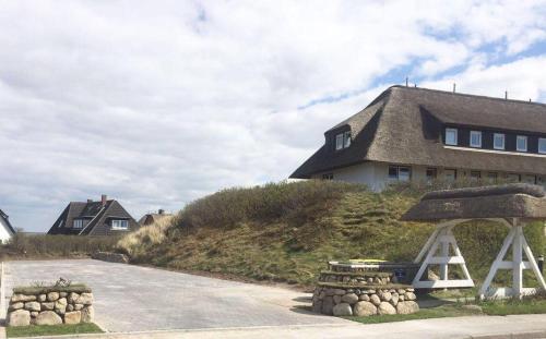 a house sitting on top of a hill next to a road at Haus-Marina in Rantum