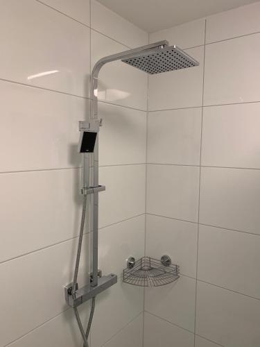 a shower with a shower head on a white wall at Haus-Marina in Rantum
