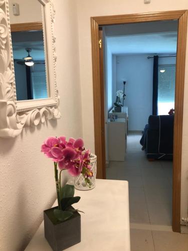 un vase de fleurs assis sur une table avec un miroir dans l'établissement BE LIKE AT HOME - IBIZA, à Alcalá de Henares