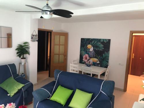 - un salon avec un canapé bleu et des oreillers verts dans l'établissement BE LIKE AT HOME - IBIZA, à Alcalá de Henares