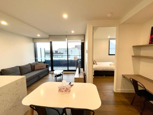 een woonkamer met een tafel en een bank bij Readyset Apartments at Marque in Melbourne