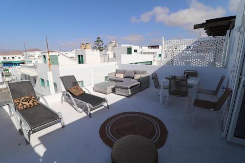 a patio with chairs and a table on a balcony at CASA MAR GINES NORTE in La Santa