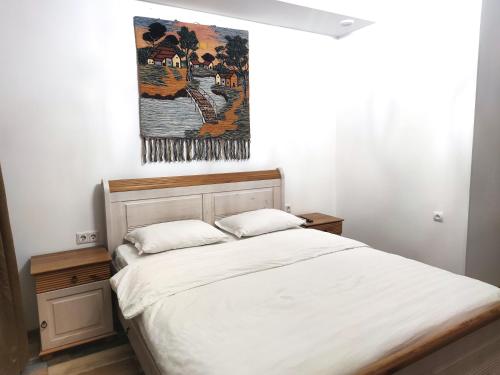 sypialnia z łóżkiem i obrazem na ścianie w obiekcie Loftik Apartments Gagarin street w mieście Ałma-Ata