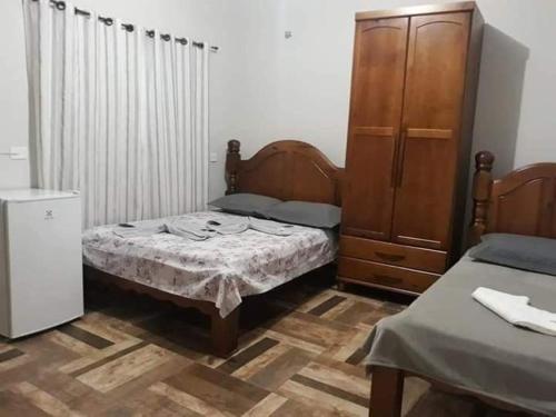 a small bedroom with a bed and a dresser at Pousada do Gelão in Lagoinha