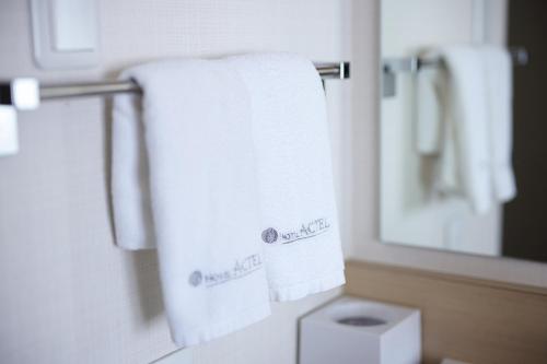 a bathroom with white towels hanging on a towel rack at Hotel Actel Nagoya Nishiki in Nagoya