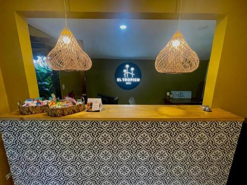 a restaurant with a reception counter with chandeliers at Hotel y Cabinas del Trópico in Guápiles
