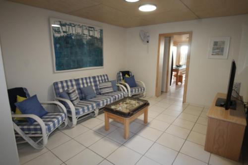 a living room with a couch and chairs and a table at The Jetty at Cowan Cowan in Cowan Cowan