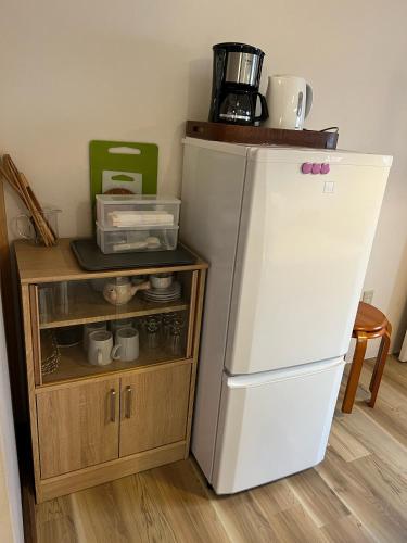 a kitchen with a white refrigerator next to a cabinet at Kyoto Osaka SUMIREYA in Takatuki