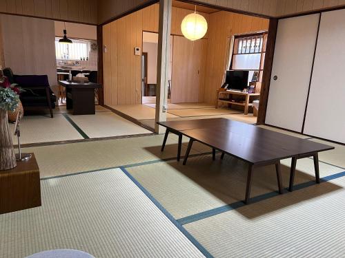 a living room with a table in the middle of it at Kyoto Osaka SUMIREYA in Takatuki
