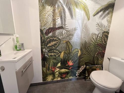 La salle de bains est pourvue d'une fresque murale représentant des plantes. dans l'établissement Maison neuve, 6 couchages, proche plage avec jardin, terrasse et parking, animaux admis. - FR-1-246A-128, à Saint-Pierre-dʼOléron