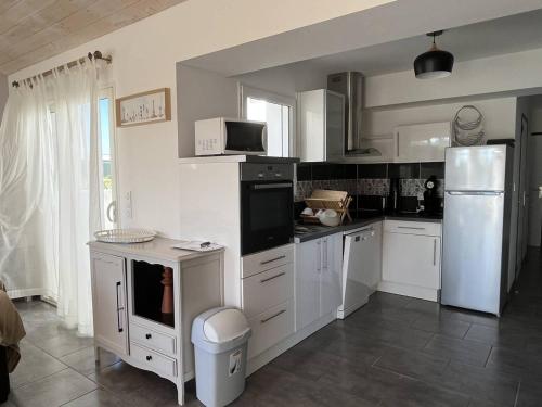 une cuisine avec des armoires blanches et un réfrigérateur blanc dans l'établissement Maison neuve, 6 couchages, proche plage avec jardin, terrasse et parking, animaux admis. - FR-1-246A-128, à Saint-Pierre-dʼOléron